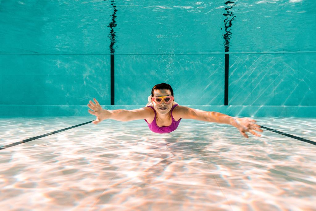 ευτυχισμένη γυναίκα σε googles κατάδυση υποβρύχιο στην πισίνα - Φωτογραφία, εικόνα