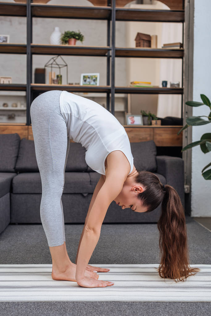 mladá žena cvičí big toe pozice doma v obývacím pokoji - Fotografie, Obrázek