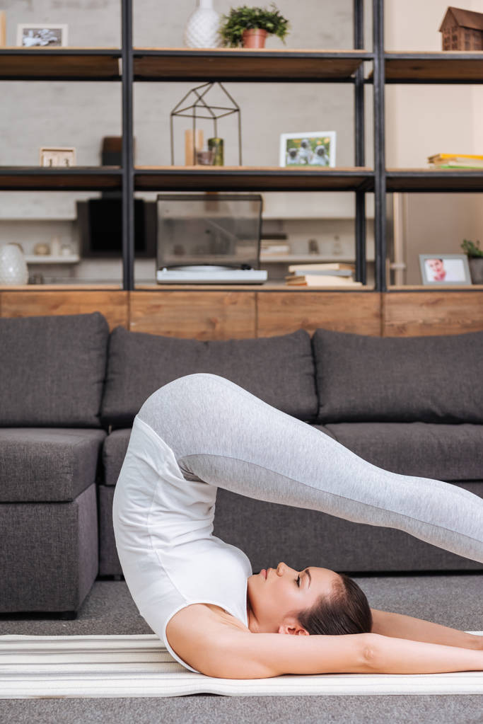 woman practicing boat pose at home in living room - Photo, Image
