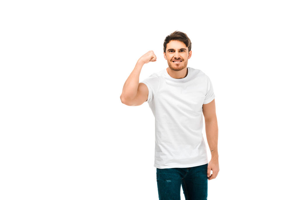 handsome young man showing biceps and smiling at camera isolated on white - Photo, Image