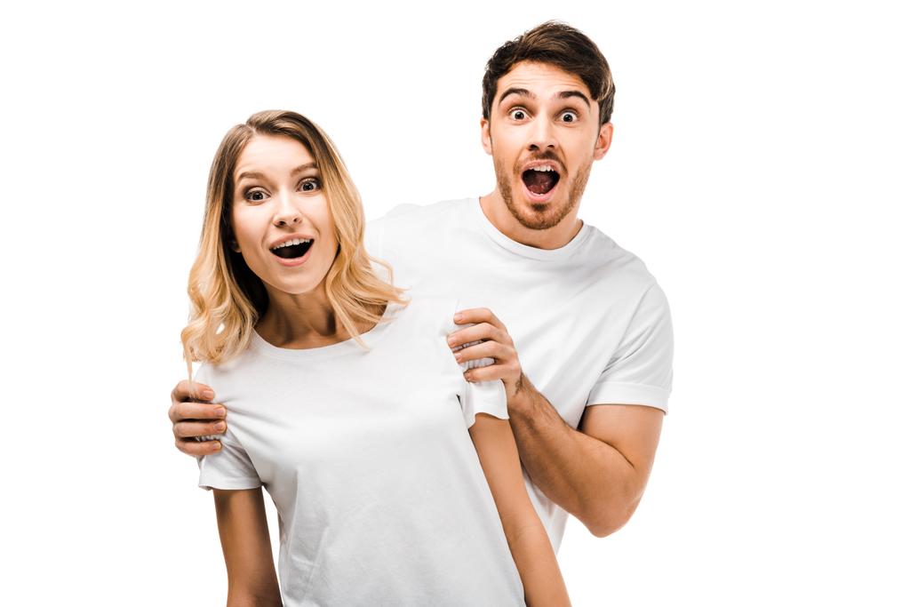 jovem casal surpreso em camisetas brancas olhando para a câmera isolada no branco
  - Foto, Imagem