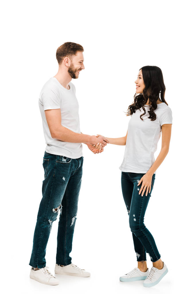 felice giovane coppia stringendo la mano e sorridendo l'un l'altro isolato su bianco
 - Foto, immagini