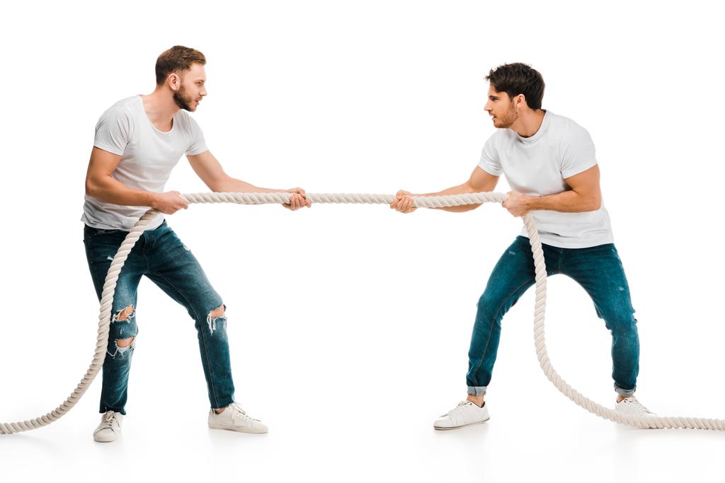 jonge mannen touw trekken en het spelen van touwtrekken geïsoleerd op wit - Foto, afbeelding
