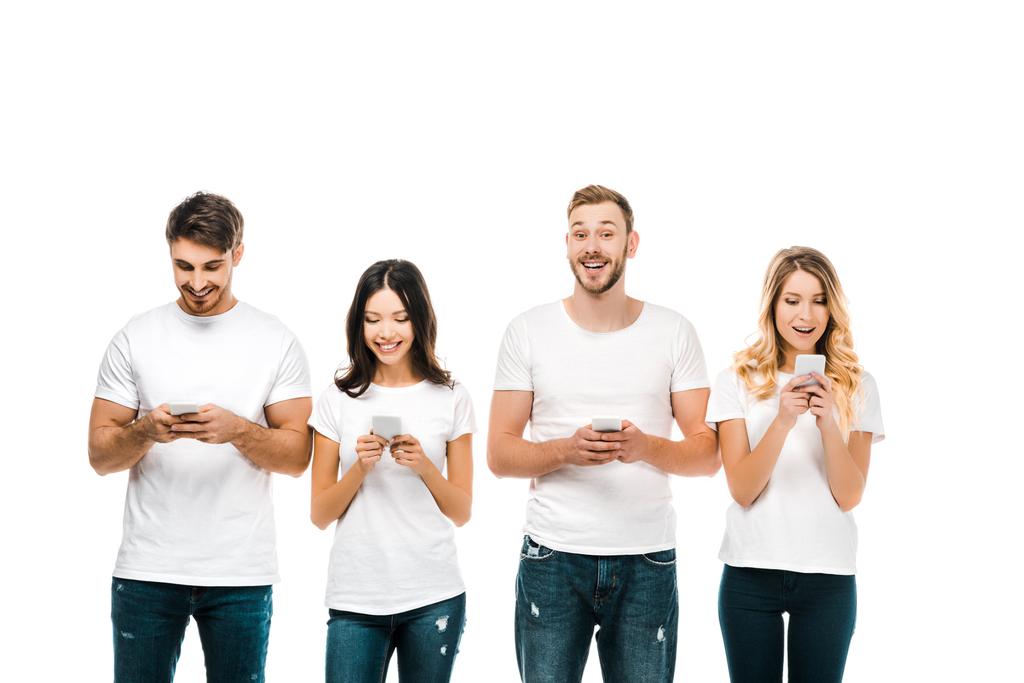 szczęśliwy młodych mężczyzn i kobiet w białych koszulkach za pomocą smartfonów na białym tle - Zdjęcie, obraz