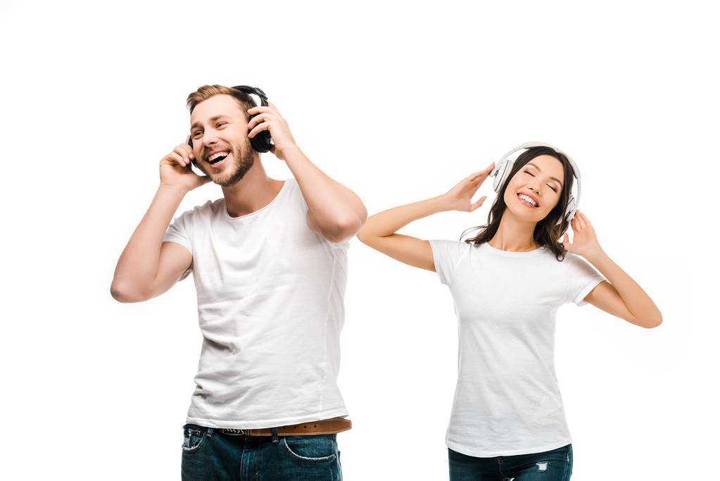iloinen nuori pari valkoisissa t-paidoissa kuuntelemassa musiikkia valkoisilla eristetyillä kuulokkeilla
  - Valokuva, kuva