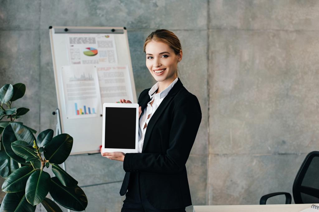 Χαμογελώντας επιχειρηματίας κρατώντας ψηφιακή δισκίο με μαύρη οθόνη - Φωτογραφία, εικόνα