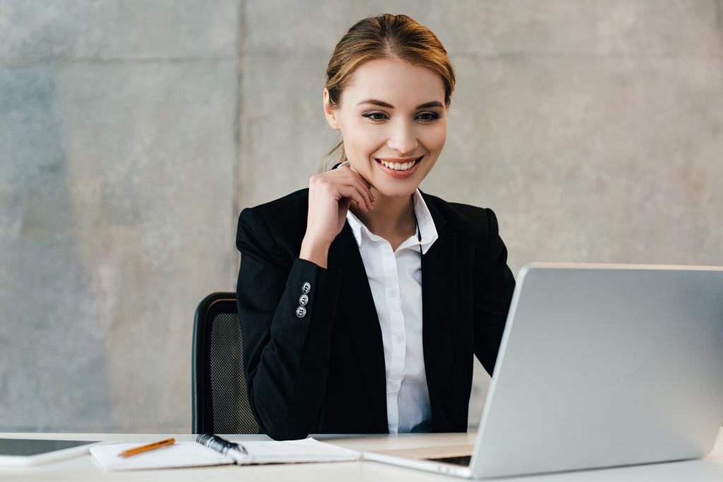 sorridente bella donna d'affari utilizzando il computer portatile in ufficio
  - Foto, immagini