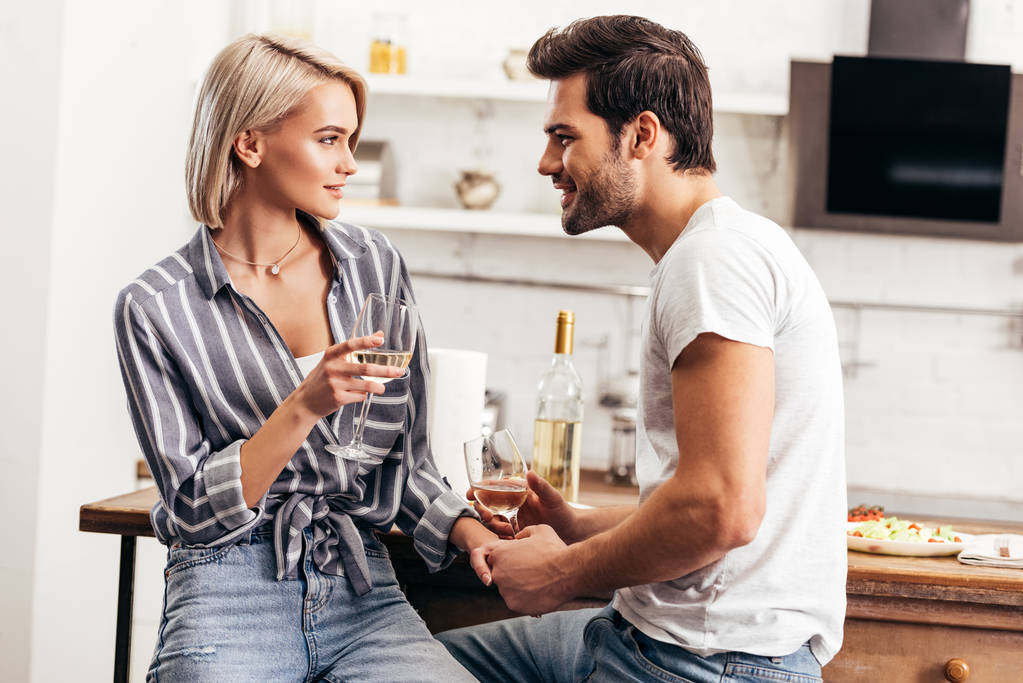 handsome boyfriend and girlfriend holding wine glasses and hands - Photo, Image