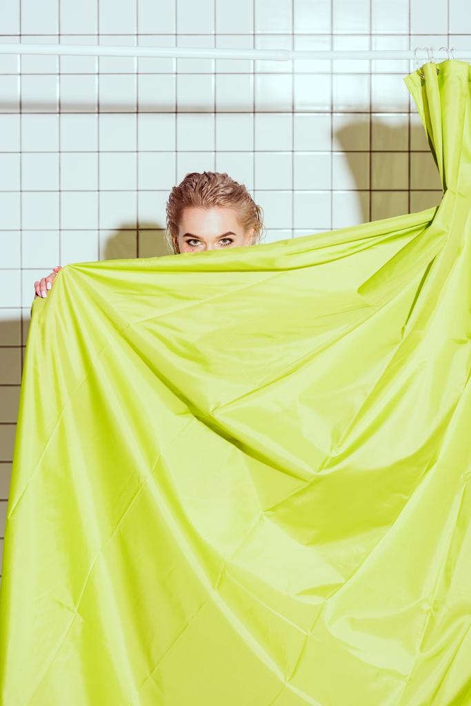 giovane donna si nasconde dietro tenda verde con spazio copia in doccia
 - Foto, immagini