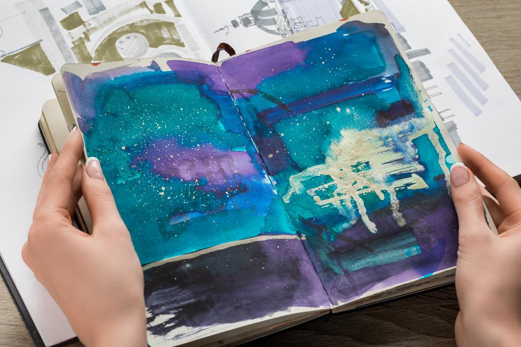 bovenaanzicht van vrouwelijke handen met laptop met abstracte blauwe tekening - Foto, afbeelding