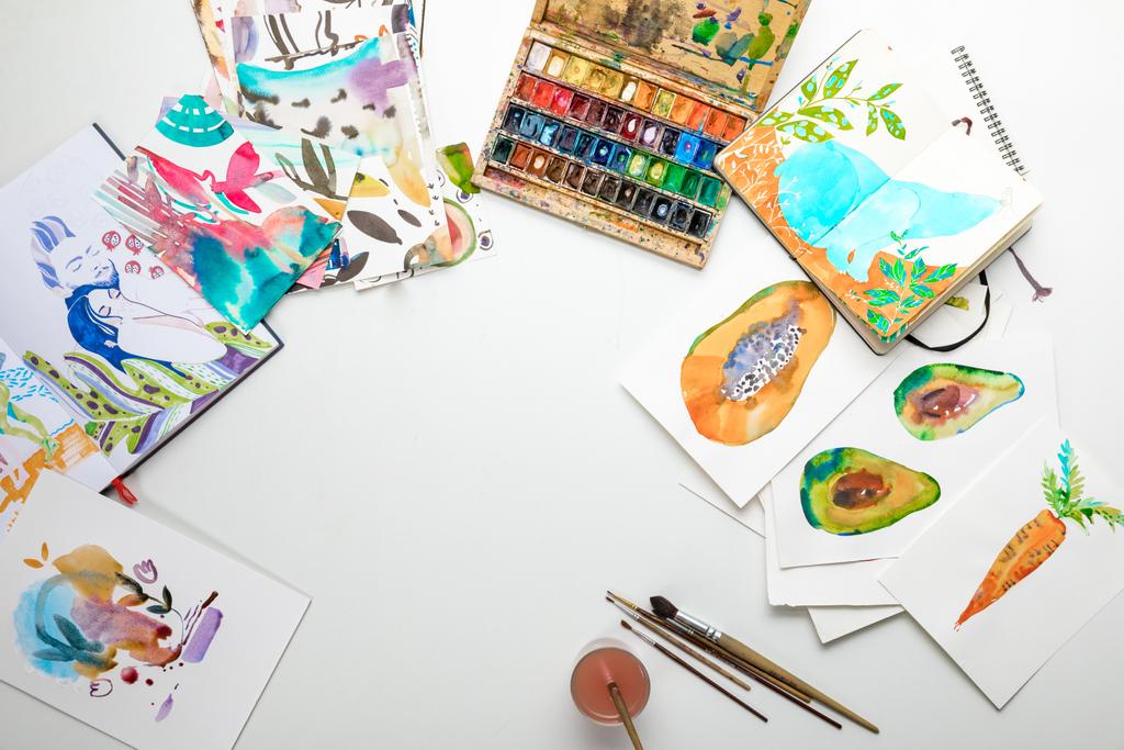 vista superior de pinturas aquarela multicoloridas e utensílios de desenho
 - Foto, Imagem