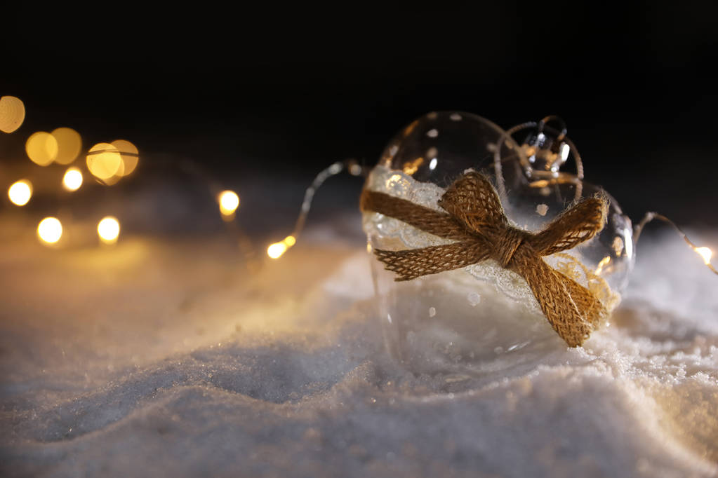 Glasherz und Lichterketten auf weißem Schnee im Freien. Raum für Text - Foto, Bild