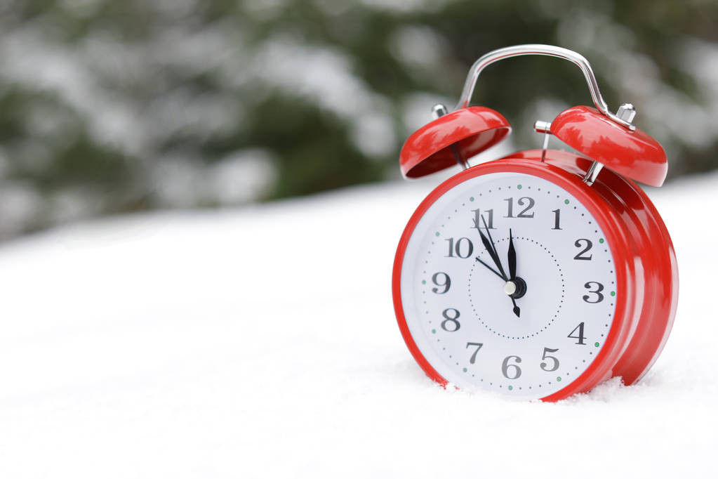 屋外白い雪に赤い目覚まし時計。テキストのためのスペース - 写真・画像
