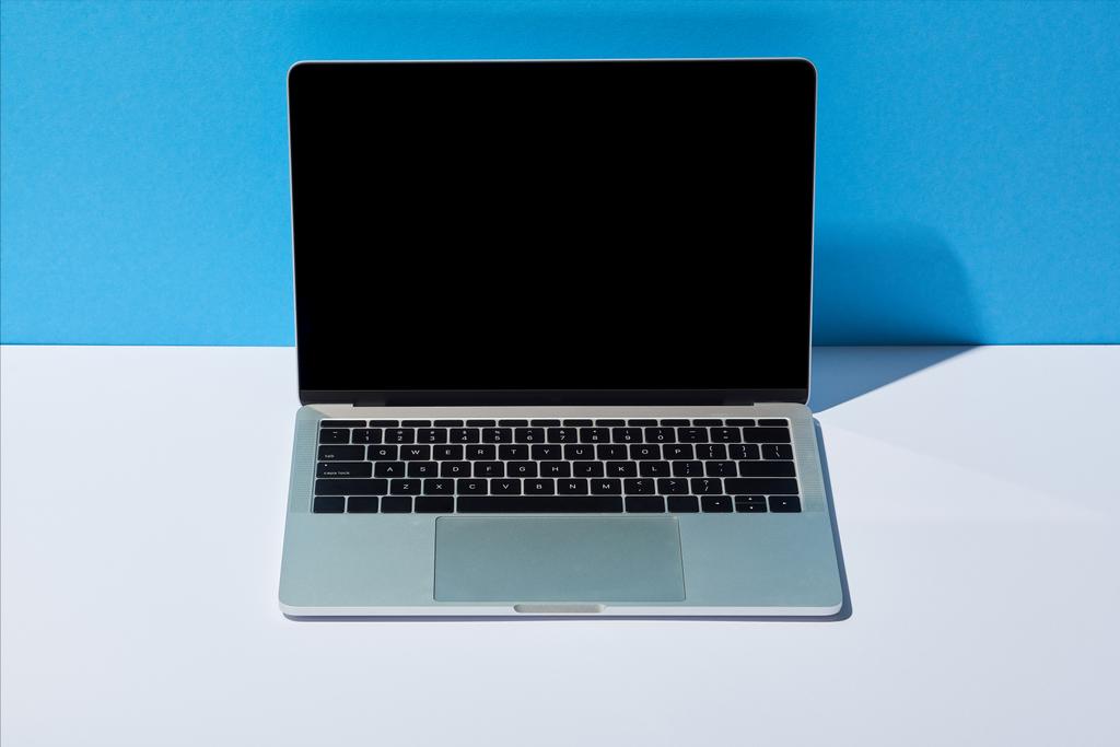 laptop com tela em branco na mesa branca e fundo azul
 - Foto, Imagem