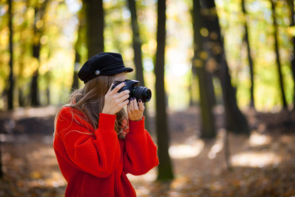 Молодая женщина развлекается с камерой делая фотографии в зеленом парке
 - Фото, изображение