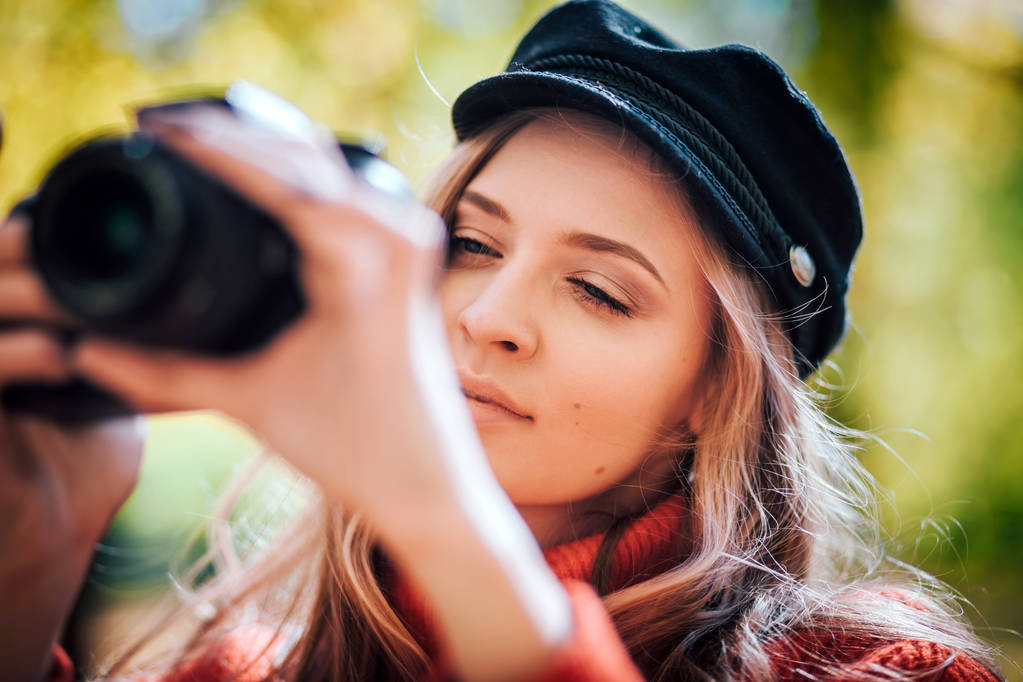 Mujer joven divirtiéndose con la cámara haciendo fotos en el parque verde
 - Foto, Imagen