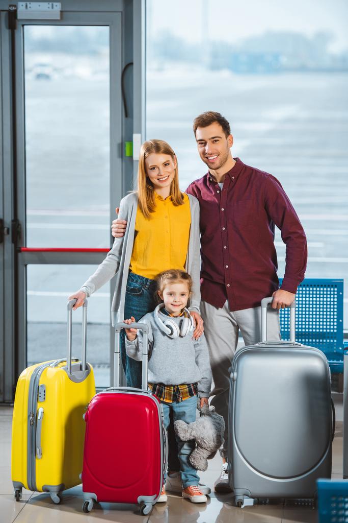 ευτυχισμένη οικογένεια στέκεται με τις αποσκευές στο σαλόνι αναμονής αναχωρήσεων - Φωτογραφία, εικόνα