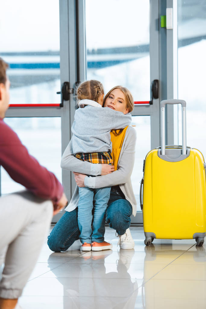 äiti halaus tytär lähellä matkatavaroita lentokentällä
  - Valokuva, kuva