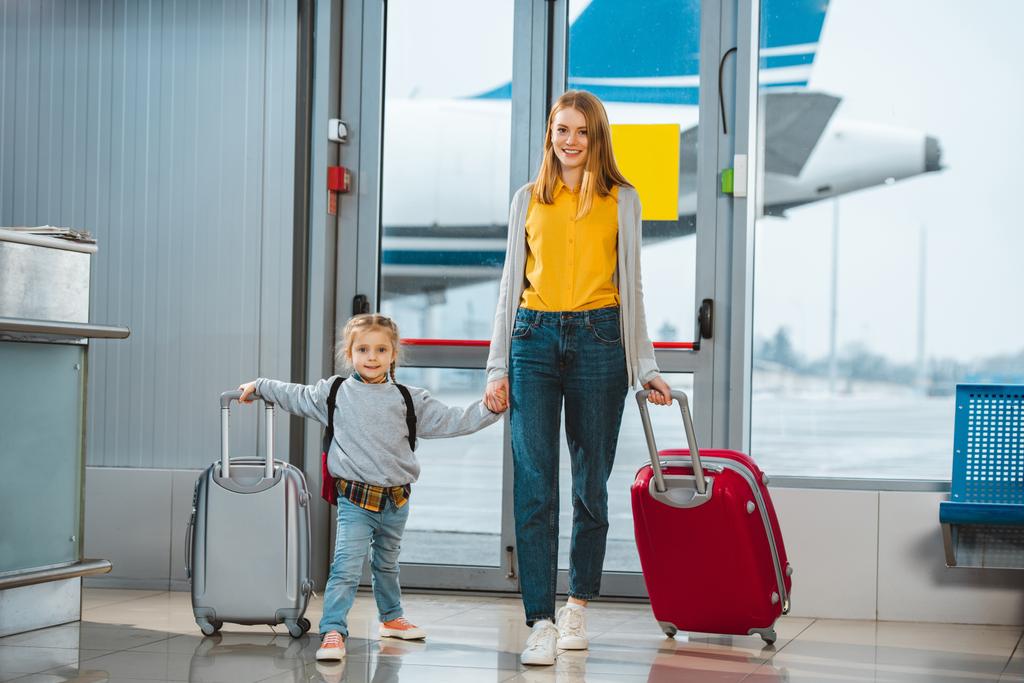 allegra madre e figlia che si tengono per mano in aeroporto
  - Foto, immagini