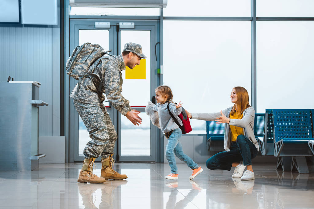 Glückliche Tochter läuft in Militäruniform auf Flughafen zum Vater  - Foto, Bild
