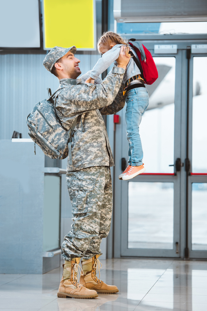 happy father in military uniform holding in arms cute daughter in airport  - Photo, Image