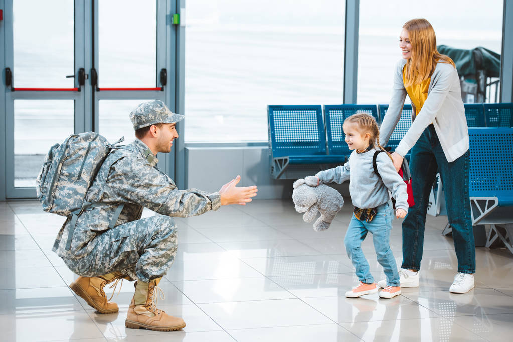 χαρούμενη κόρη τρέχει ευτυχής πατέρας με στρατιωτική στολή στο αεροδρόμιο  - Φωτογραφία, εικόνα