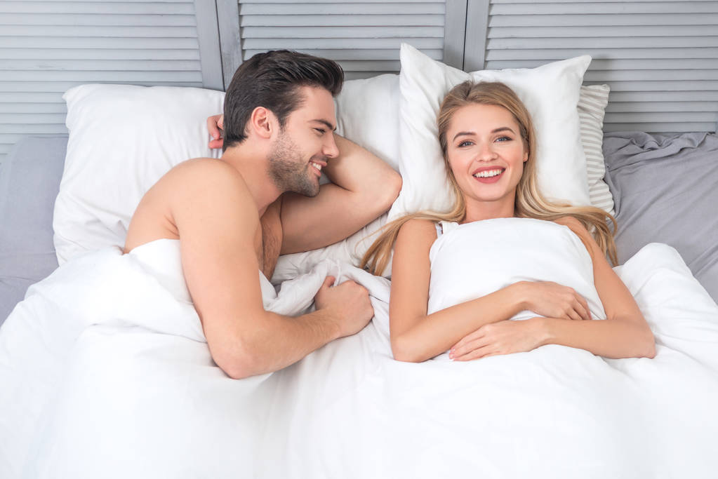 çıplak genç çiftin birlikte yatakta havai görünümü - Fotoğraf, Görsel