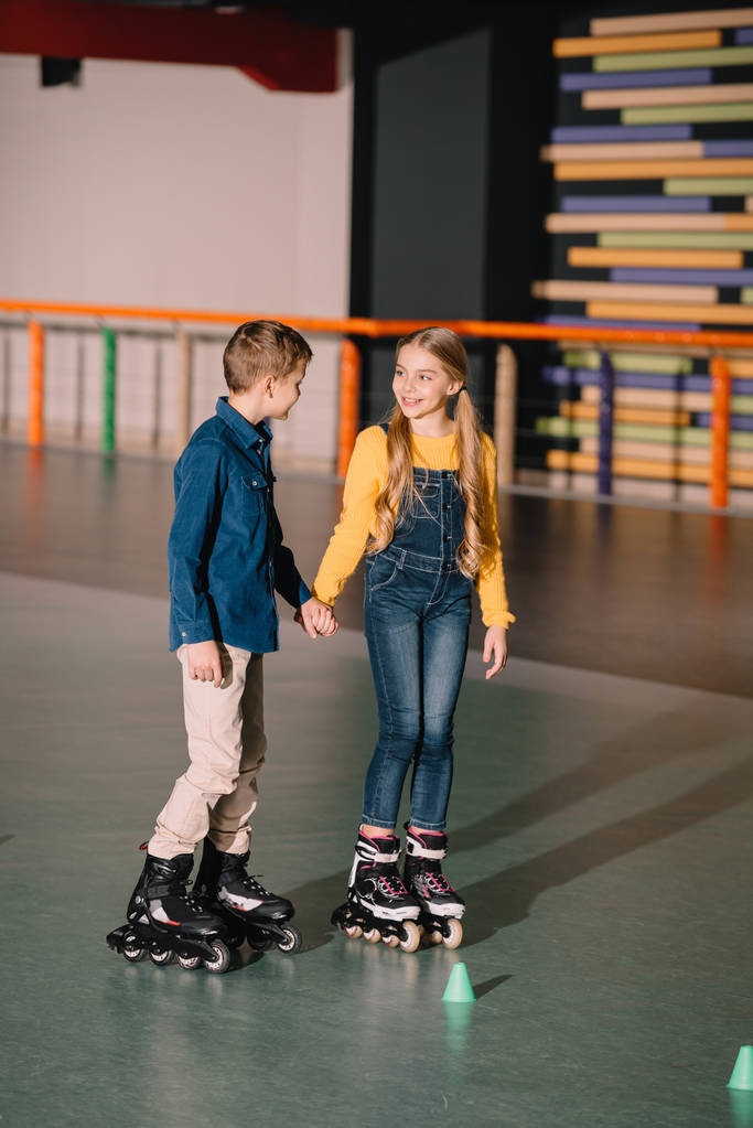 Mooie lachende schaatsen en hand in hand - Foto, afbeelding