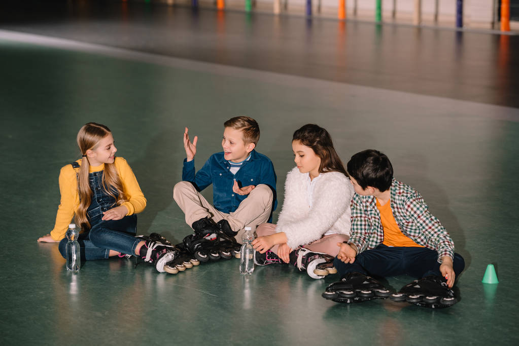 Enfants en patins à roulettes souriant et parlant autour
 - Photo, image