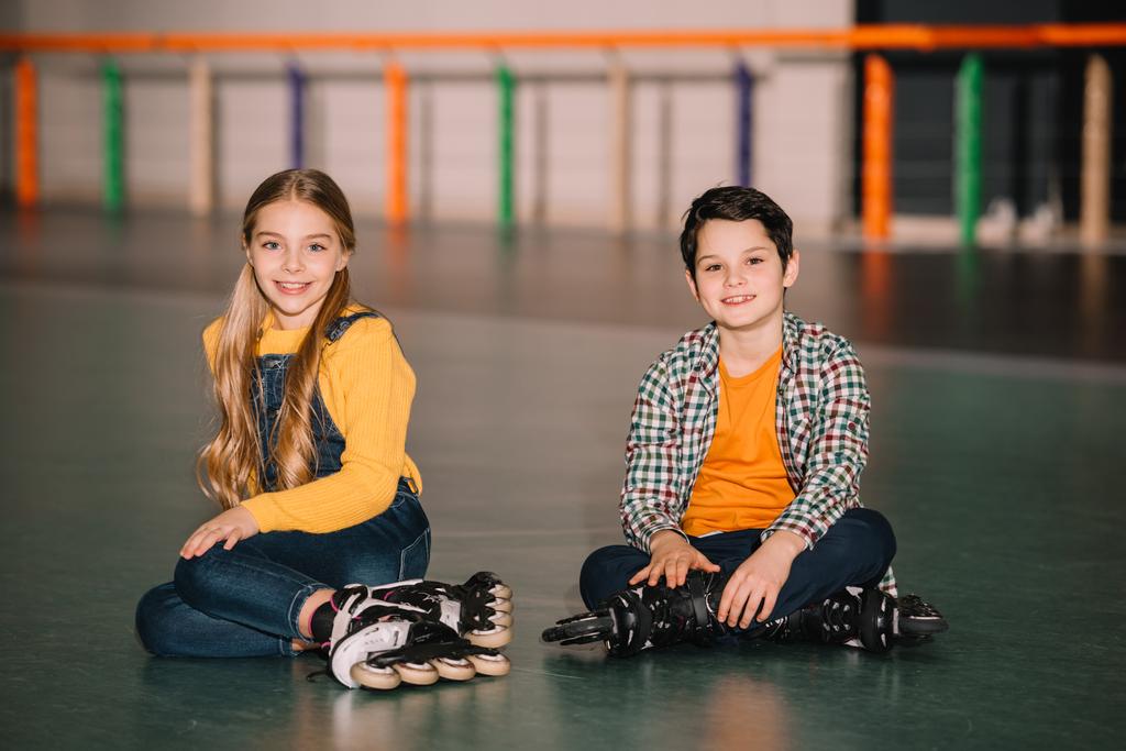 Крытый снимок улыбающихся детей на роликовых коньках, веселящихся вместе
 - Фото, изображение