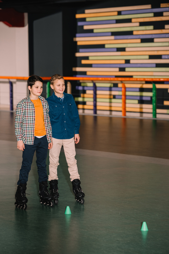irmãozinhos em patins posando com sorriso
 - Foto, Imagem