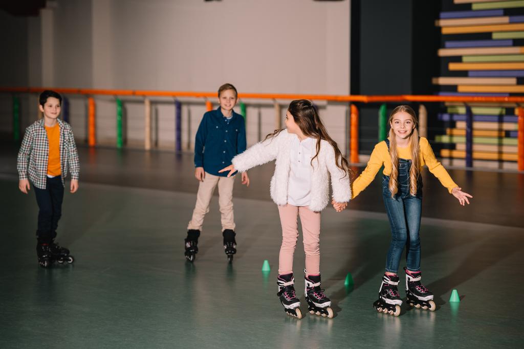 Friends in roller skaters laughing and holding hands  - Photo, Image