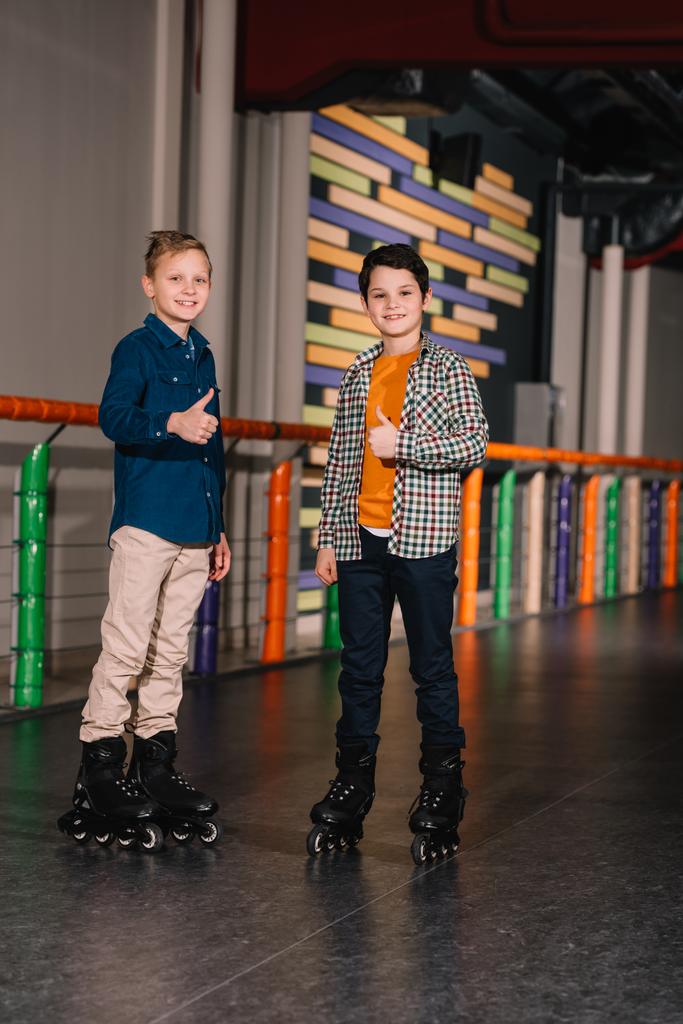 Niños preadolescentes en patines posando con los pulgares hacia arriba
 - Foto, imagen