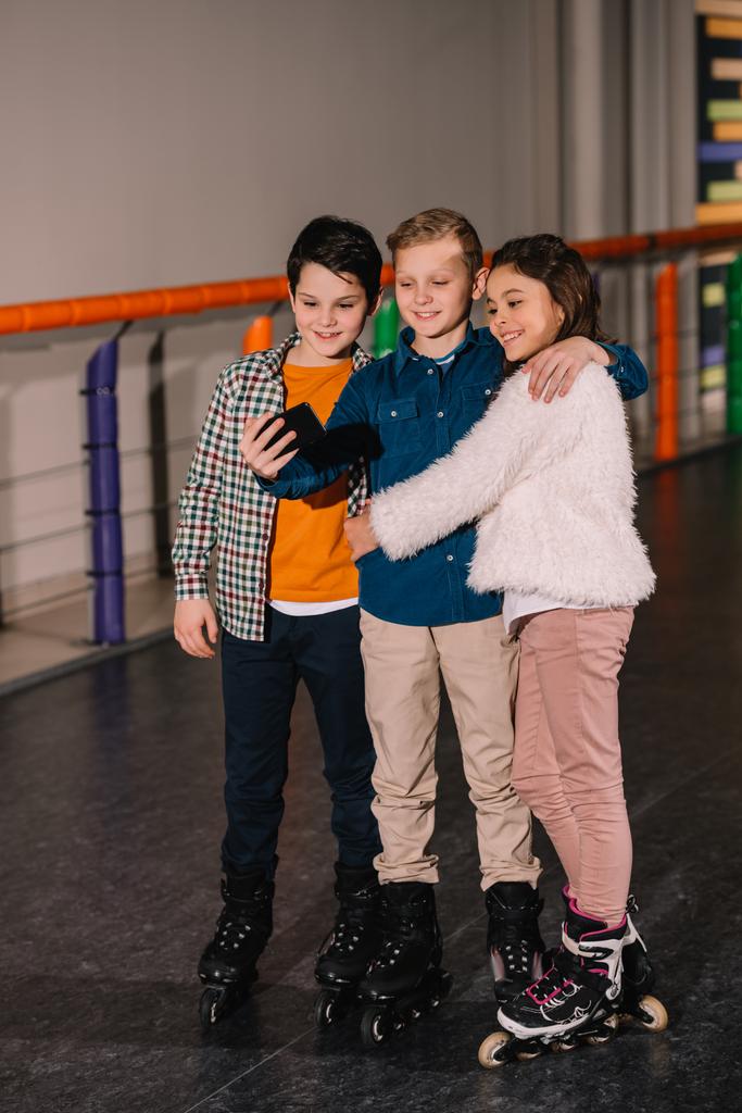 Kinderen omarmen terwijl het maken van de selfie op de roller ijsbaan - Foto, afbeelding