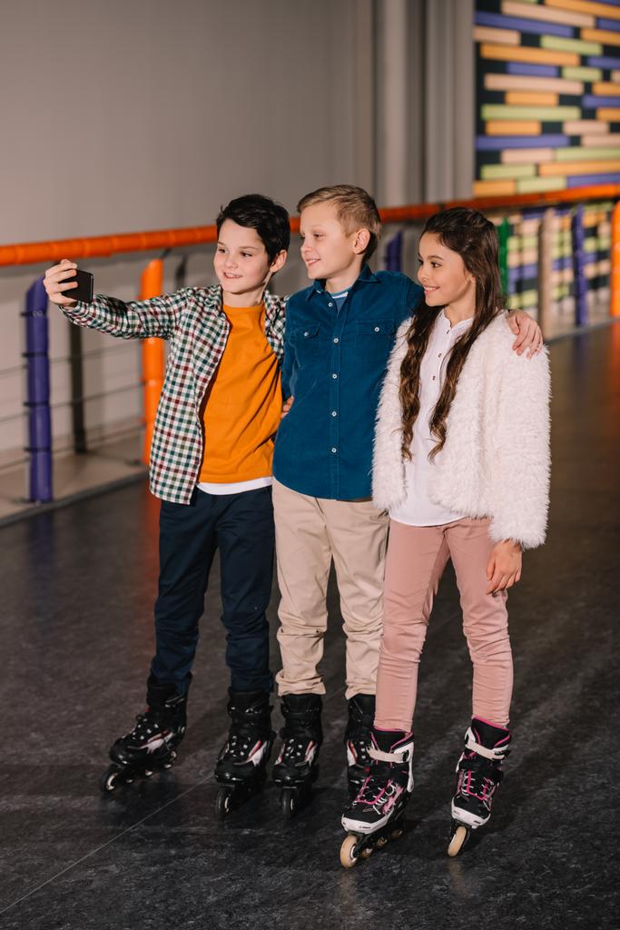Crianças abraços na pista de rolo e fazer selfie
 - Foto, Imagem