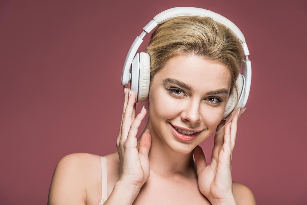 piękne, uśmiechający się dziewczyna słuchania muzyki ze słuchawkami, na różowym tle - Zdjęcie, obraz