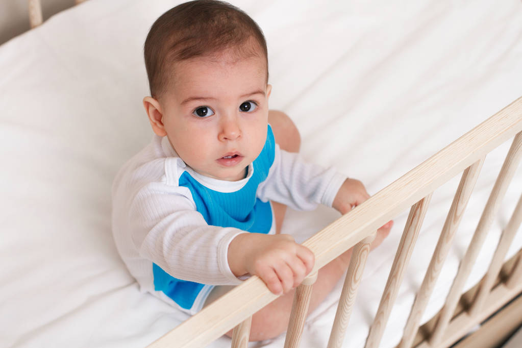 Αξιολάτρευτο μωρό παιδί στο κρεβάτι white διερεύνηση στην κάμερα - Φωτογραφία, εικόνα
