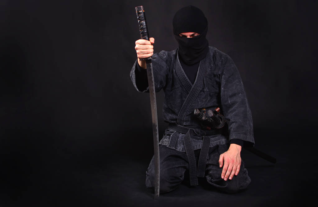 Κουρασμένος ninja σε κιμονό με katana κάθεται στην αγκαλιά του - Φωτογραφία, εικόνα