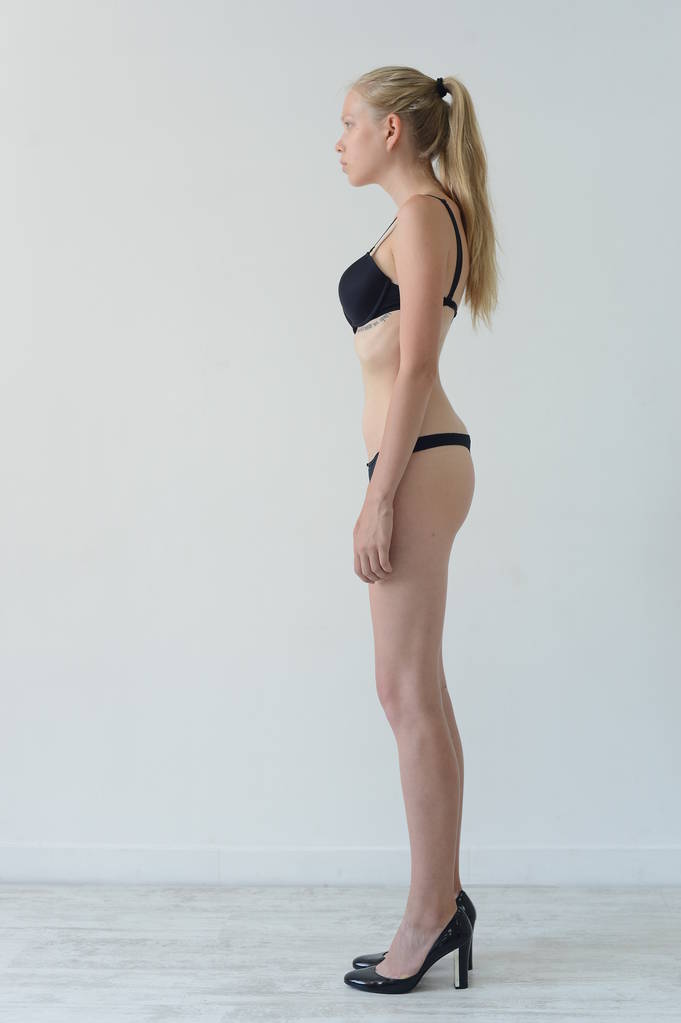 modelo prueba chica en lencería negra con tatuaje posando en Studio sobre fondo gris
 - Foto, imagen