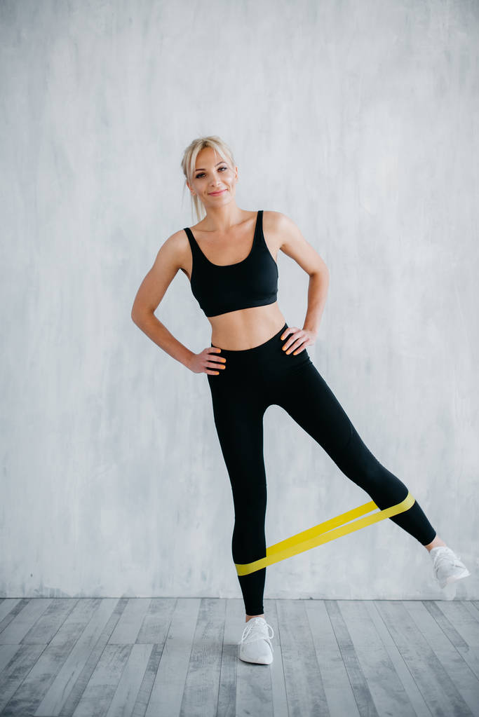 fitness kadın sarı fitness sakız ile bacak egzersizleri yapıyor - Fotoğraf, Görsel