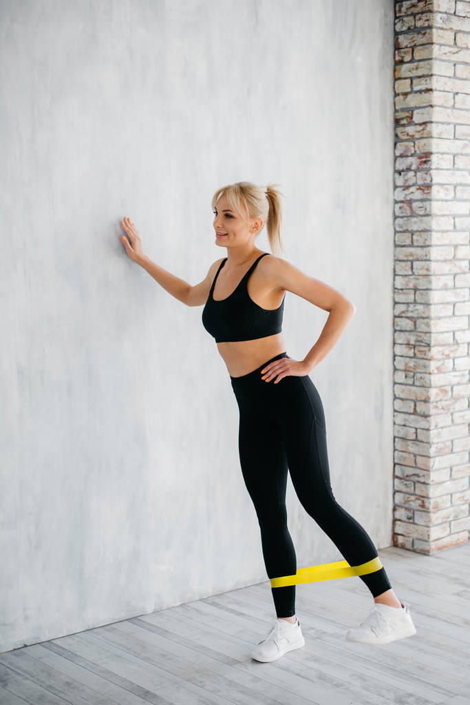 fitness žena dělá cvičení nohou s žlutým fitness guma - Fotografie, Obrázek