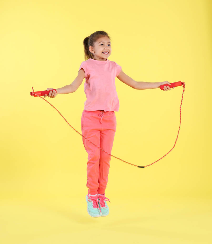 Портрет дівчини, що стрибає на мотузці на кольоровому фоні
 - Фото, зображення