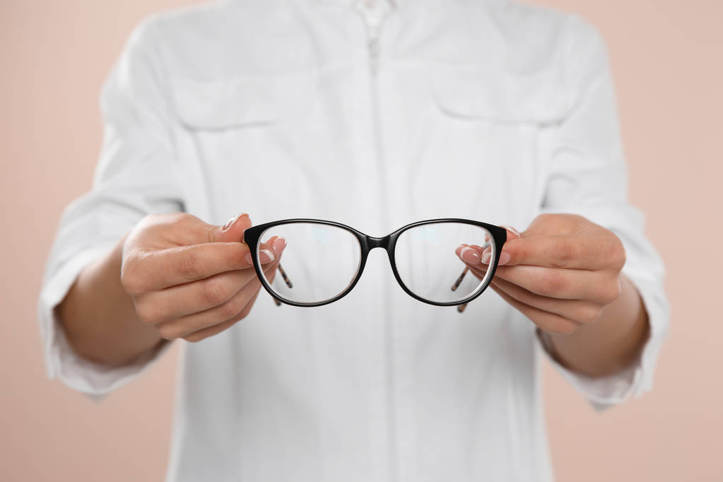 Augenärztin mit Brille auf hellem Hintergrund, Nahaufnahme - Foto, Bild