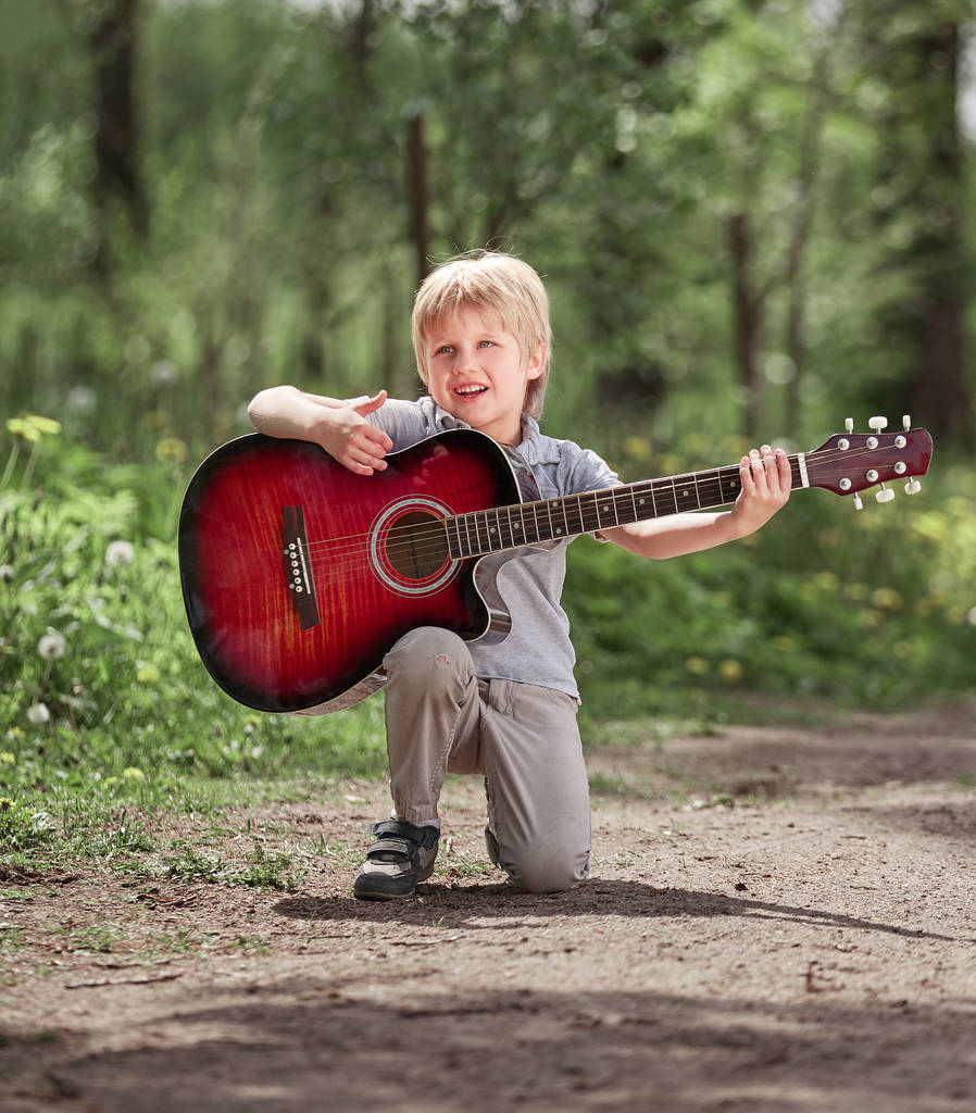 μικρό αγόρι τραγουδά ένα τραγούδι στο μονοπάτι στο πάρκο - Φωτογραφία, εικόνα