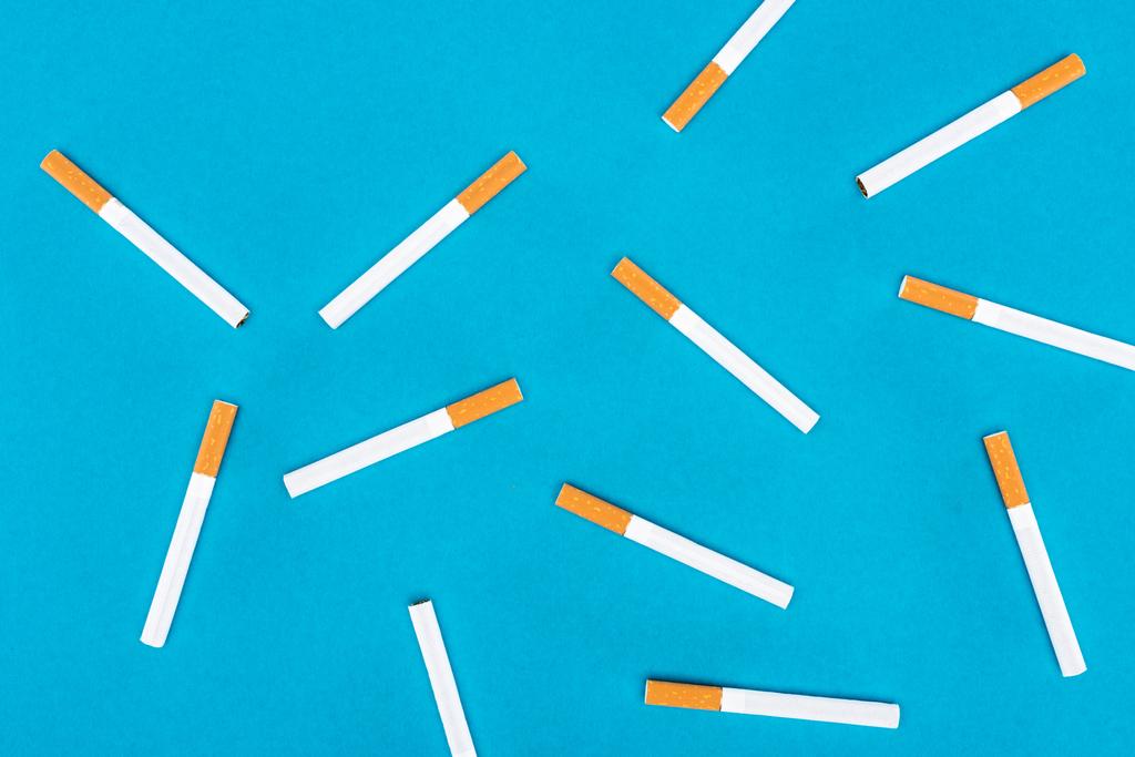Puesta plana de cigarrillos aislados en azul
  - Foto, Imagen