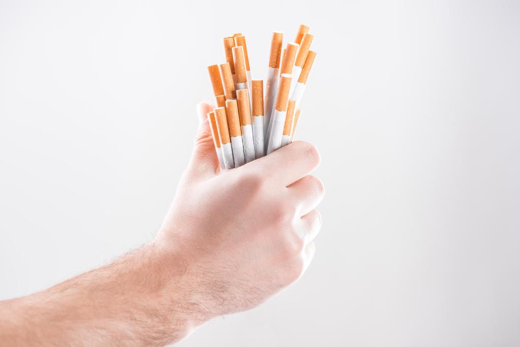 Vista recortada del hombre sosteniendo cigarrillos en la mano aislado en gris
 - Foto, imagen