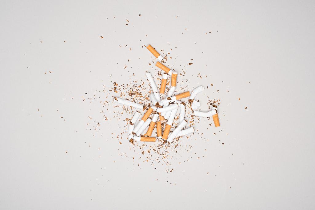 Blick von oben auf kaputte Zigaretten isoliert auf grau, Konzept Rauchstopp - Foto, Bild