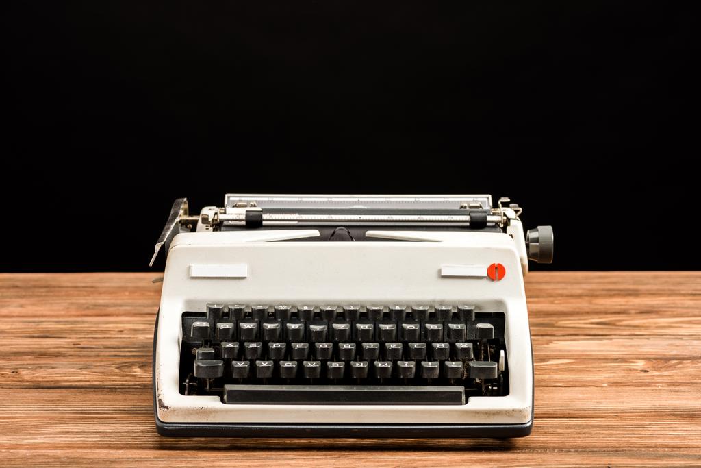 vintage typewriter on wooden table isolated on black - Photo, Image