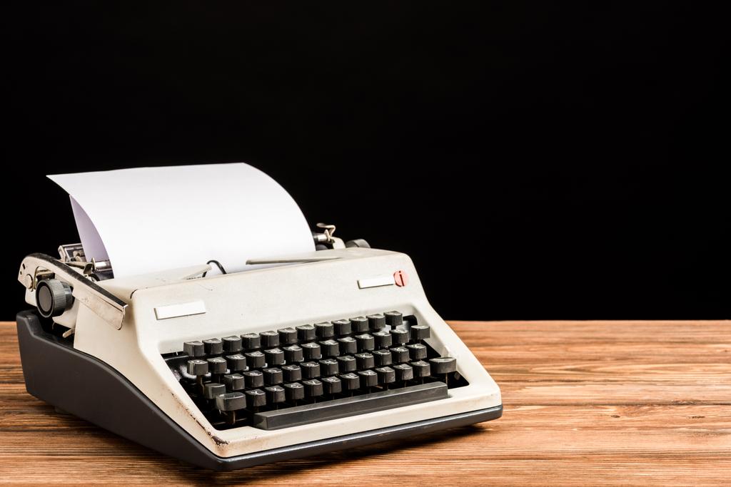 macchina da scrivere vintage con carta su tavolo in legno isolato su nero
 - Foto, immagini