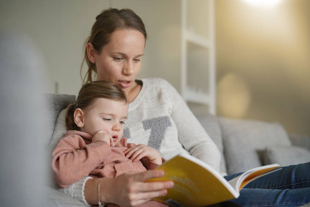 Мати і молода донька читають історію разом вдома
 - Фото, зображення